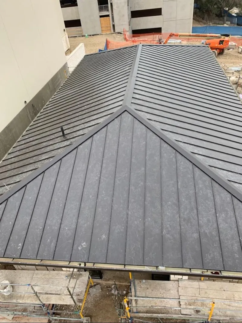 Commercial metal roof construction with crane equipment in Shasta Lake