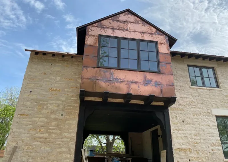 Copper metal panel facade on a stone building for Skylight Installation in Shasta Lake